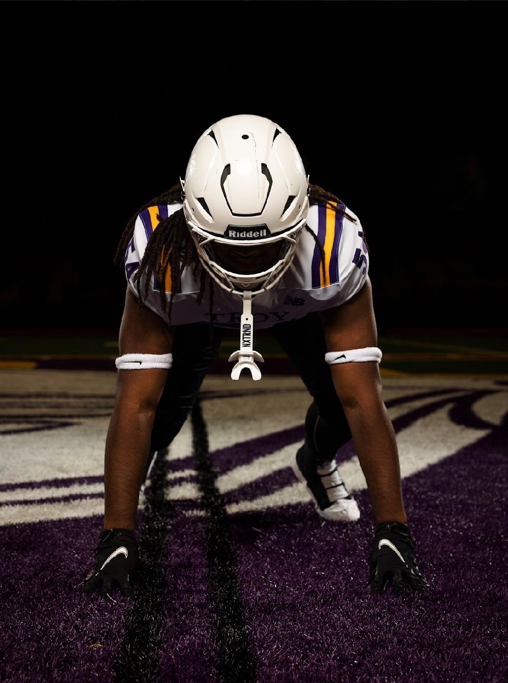 Joseph Fleuriot III in a football stance on the field at night